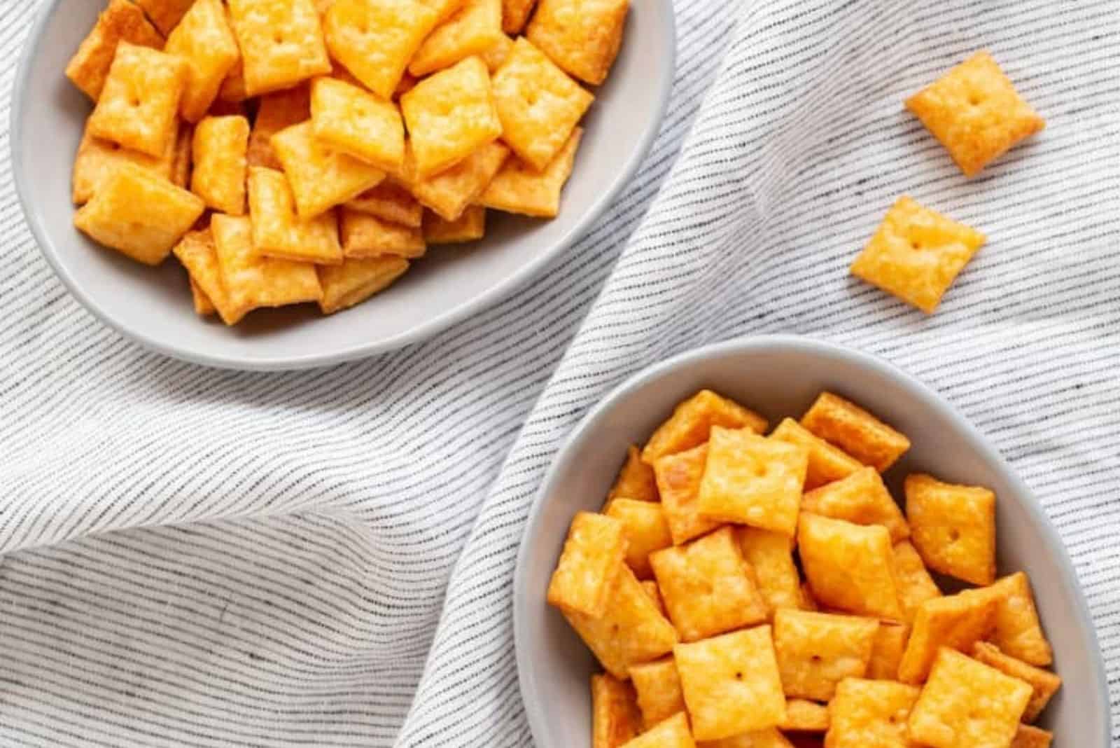 Cheez-Its en cuencos blancos sobre un mantel blanco