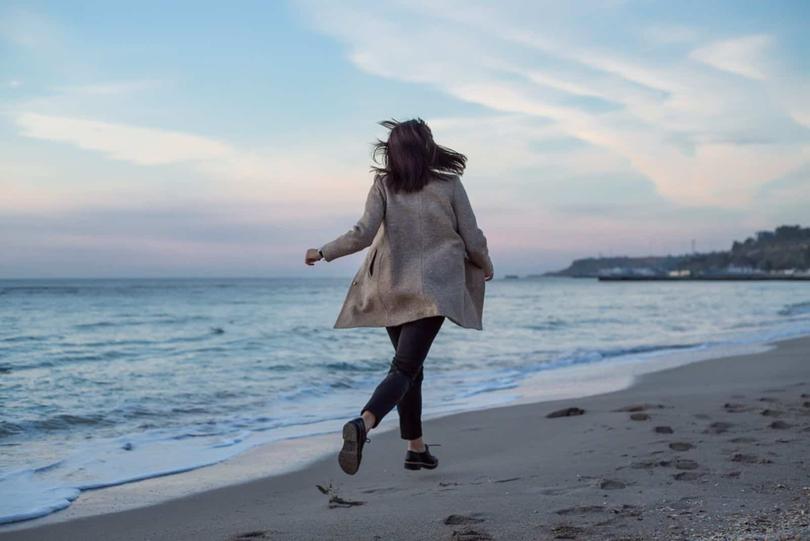 chica corriendo en la playa del mar