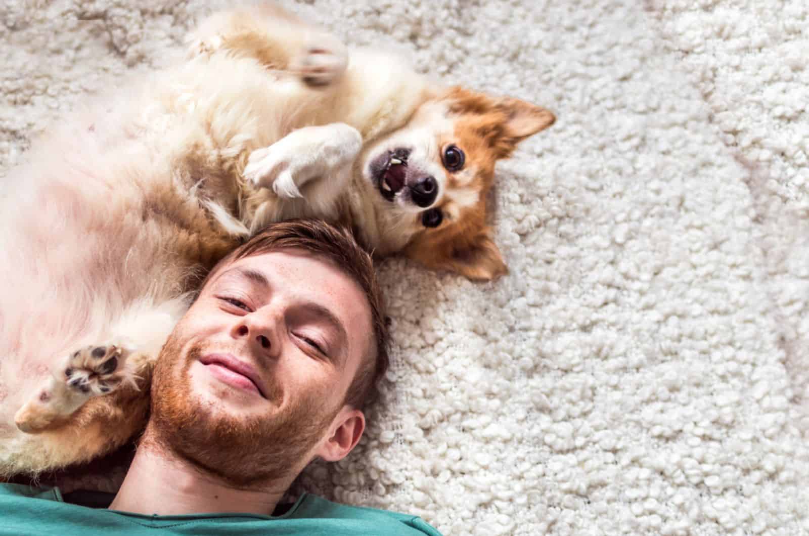 hombre y su perro tumbados en la alfombra