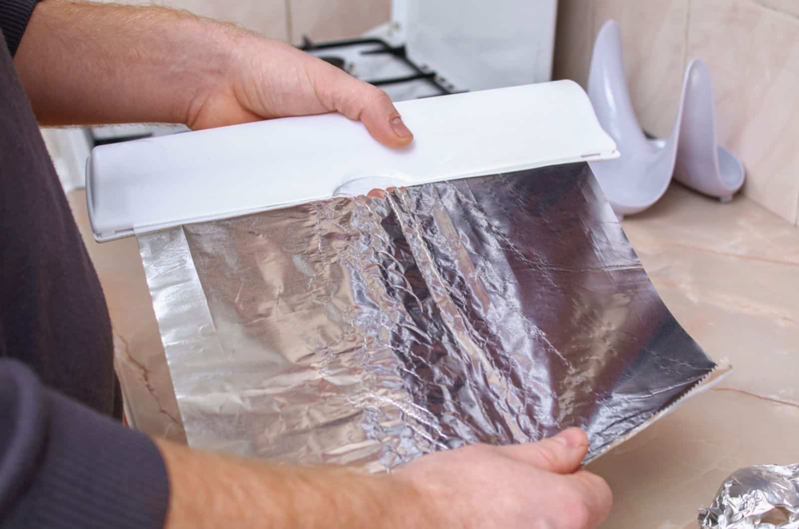desgarra el papel de aluminio de un dispensador de plástico