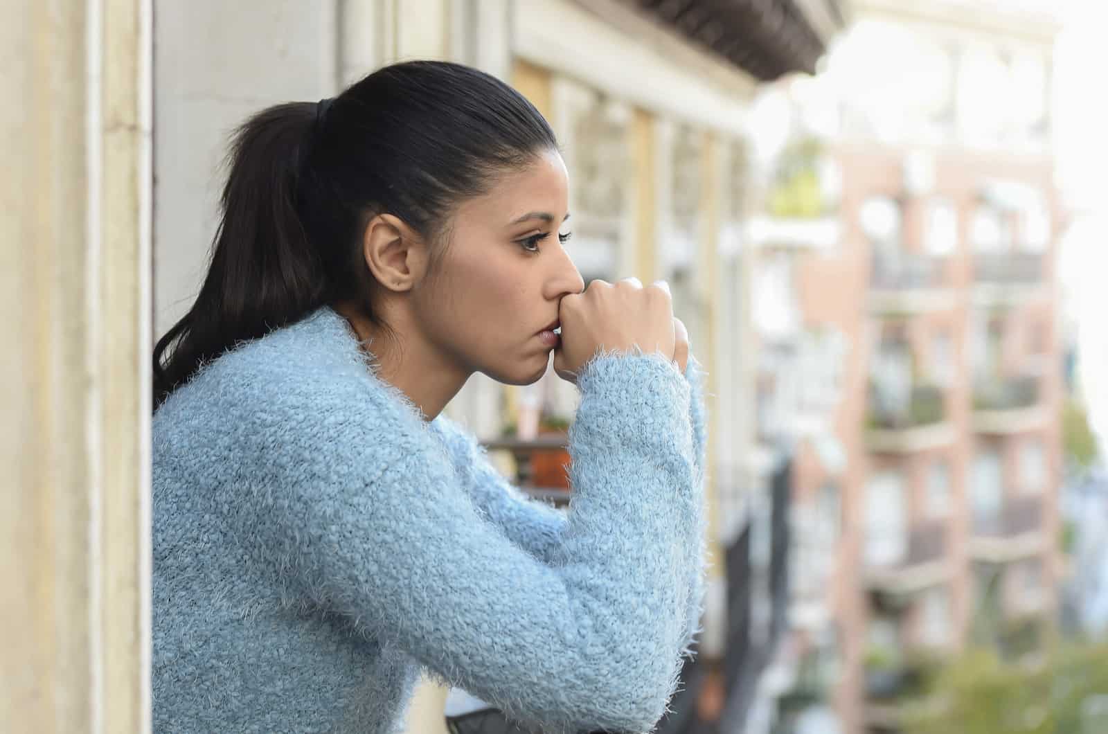 mujer triste en pensamientos profundos mirando a la calle