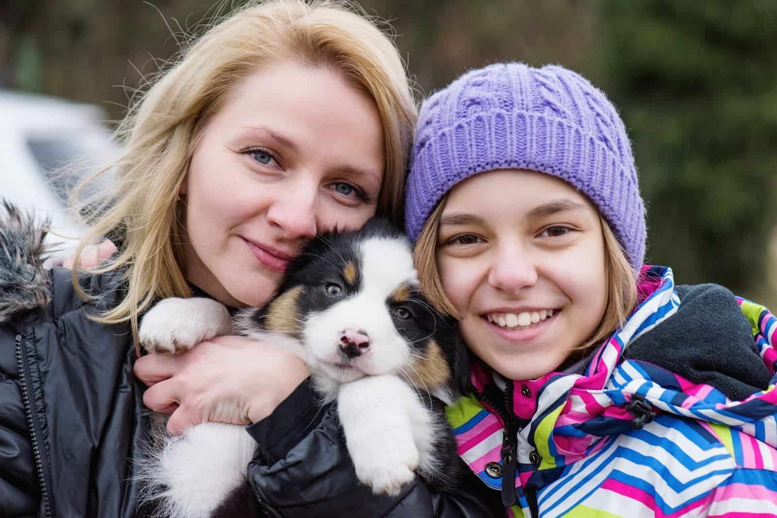 adolescente y mamá jugando con cachorro