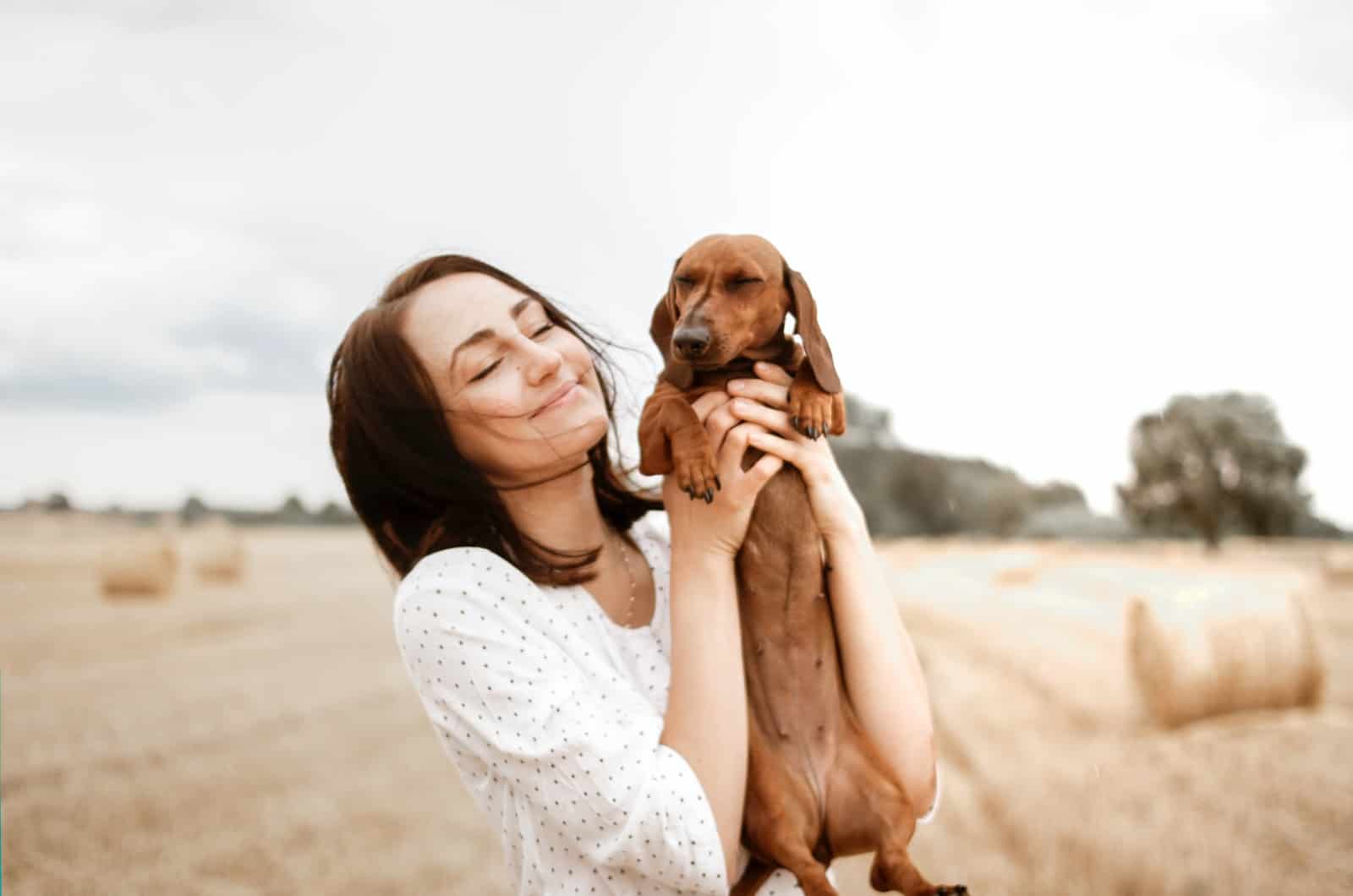 mujer sosteniendo a su perro