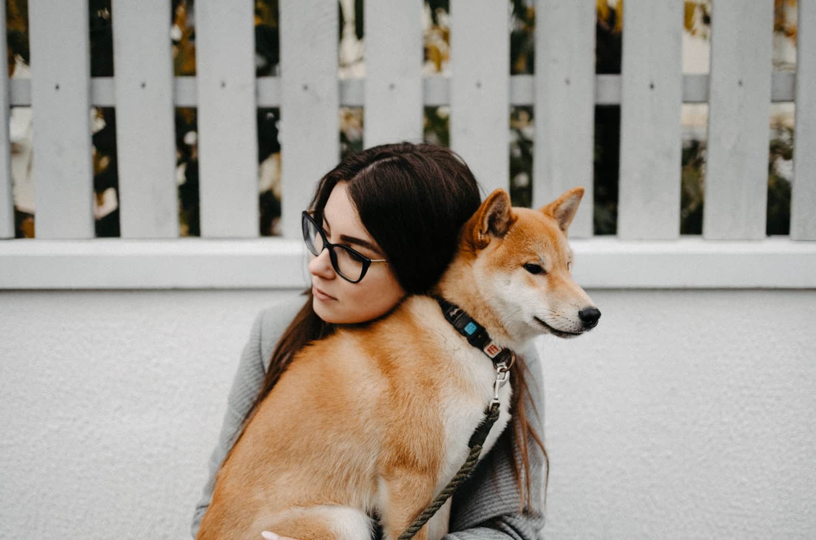 mujer abrazando a su perro akita inu