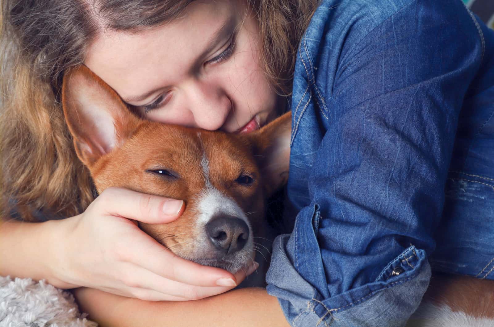 mujer abrazando a su perro moribundo