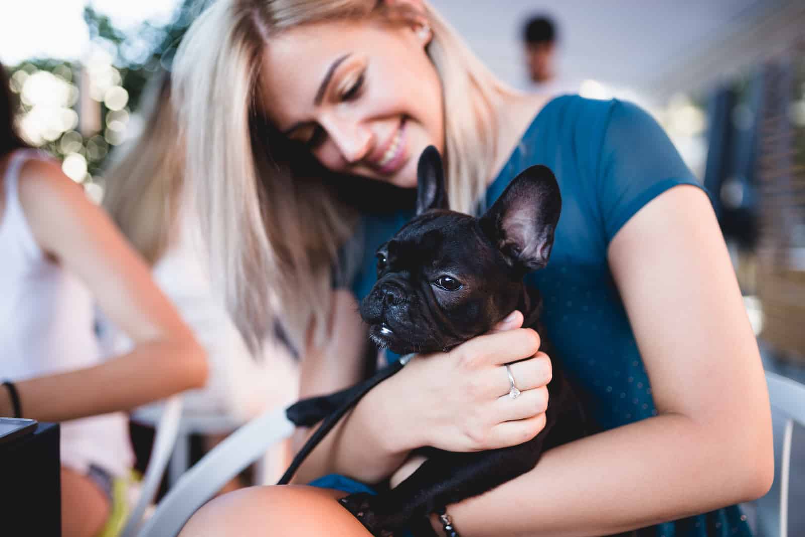 mujer abrazando su cachorro de bulldog francés