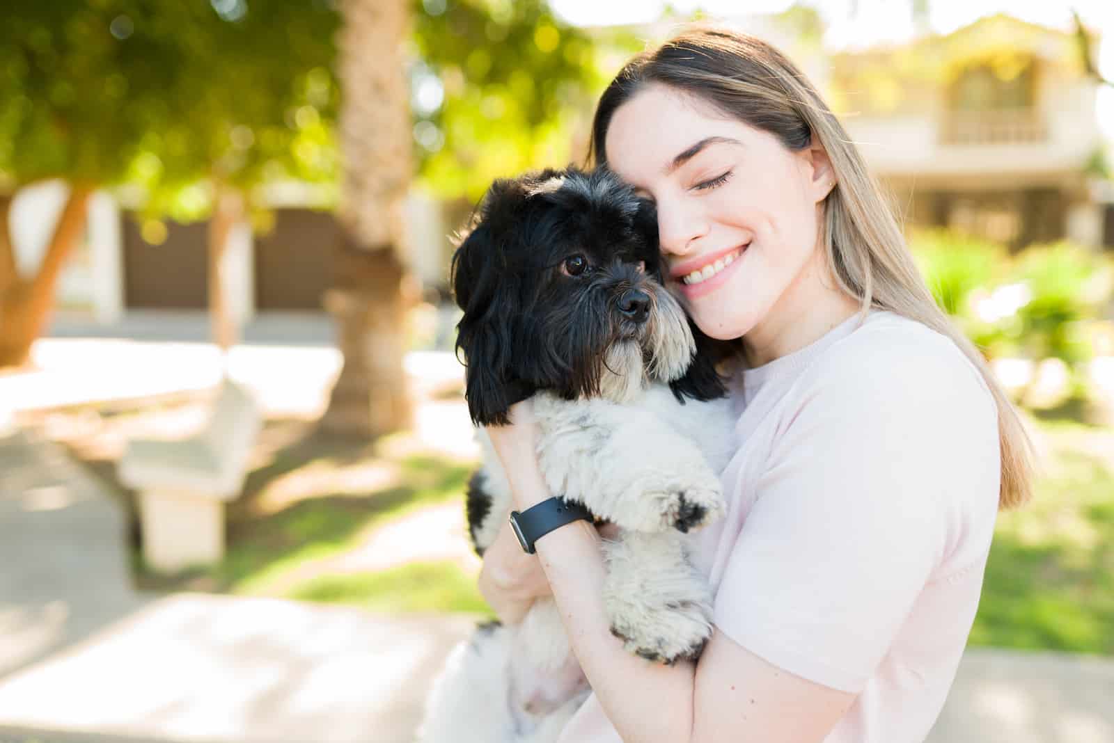 mujer abrazando a su shih tzu mascota