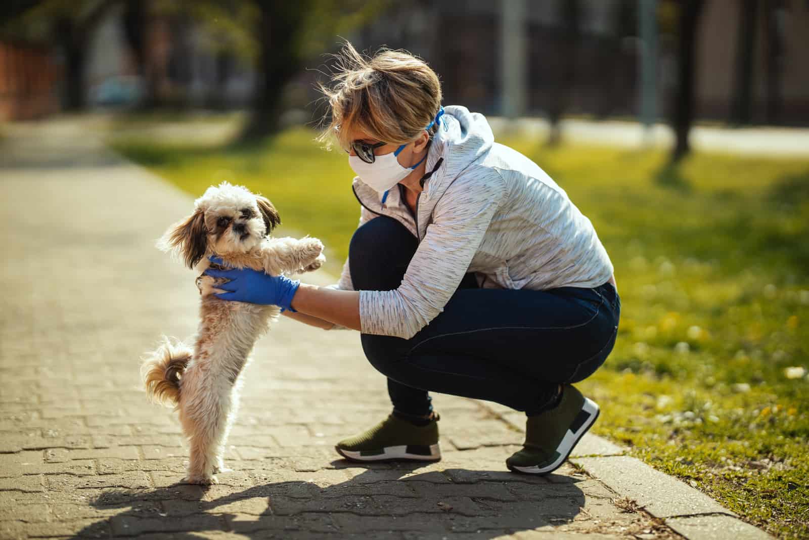 mujer en un parque sosteniendo a su perro