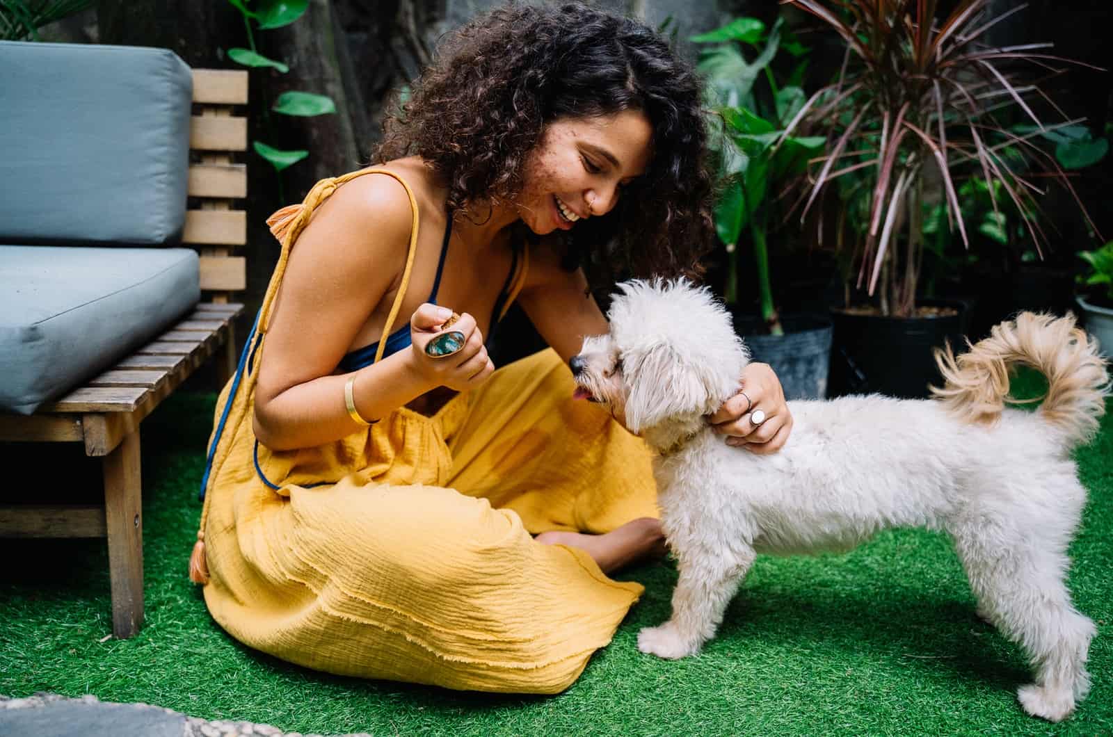 mujer con un vestido amarillo junto a su perro