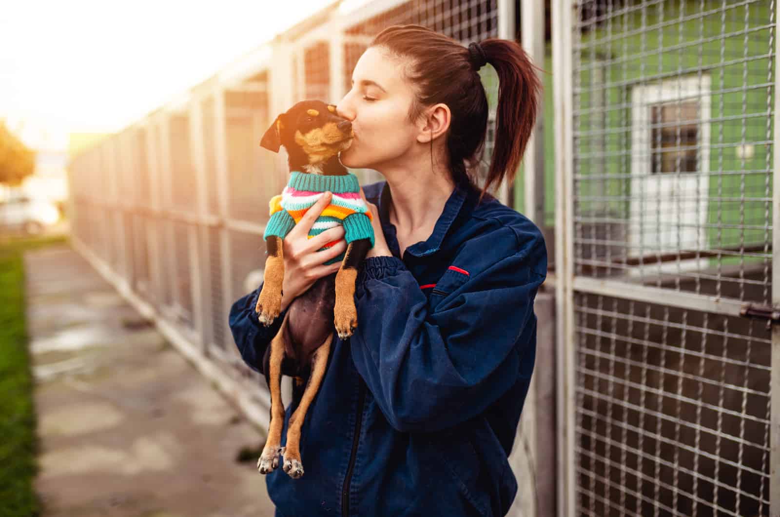 mujer besando un perro en el refugio tras adopción