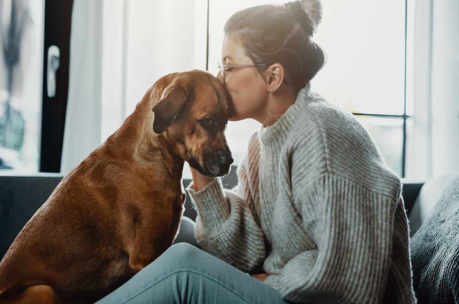 mujer besando a su perro enfermo