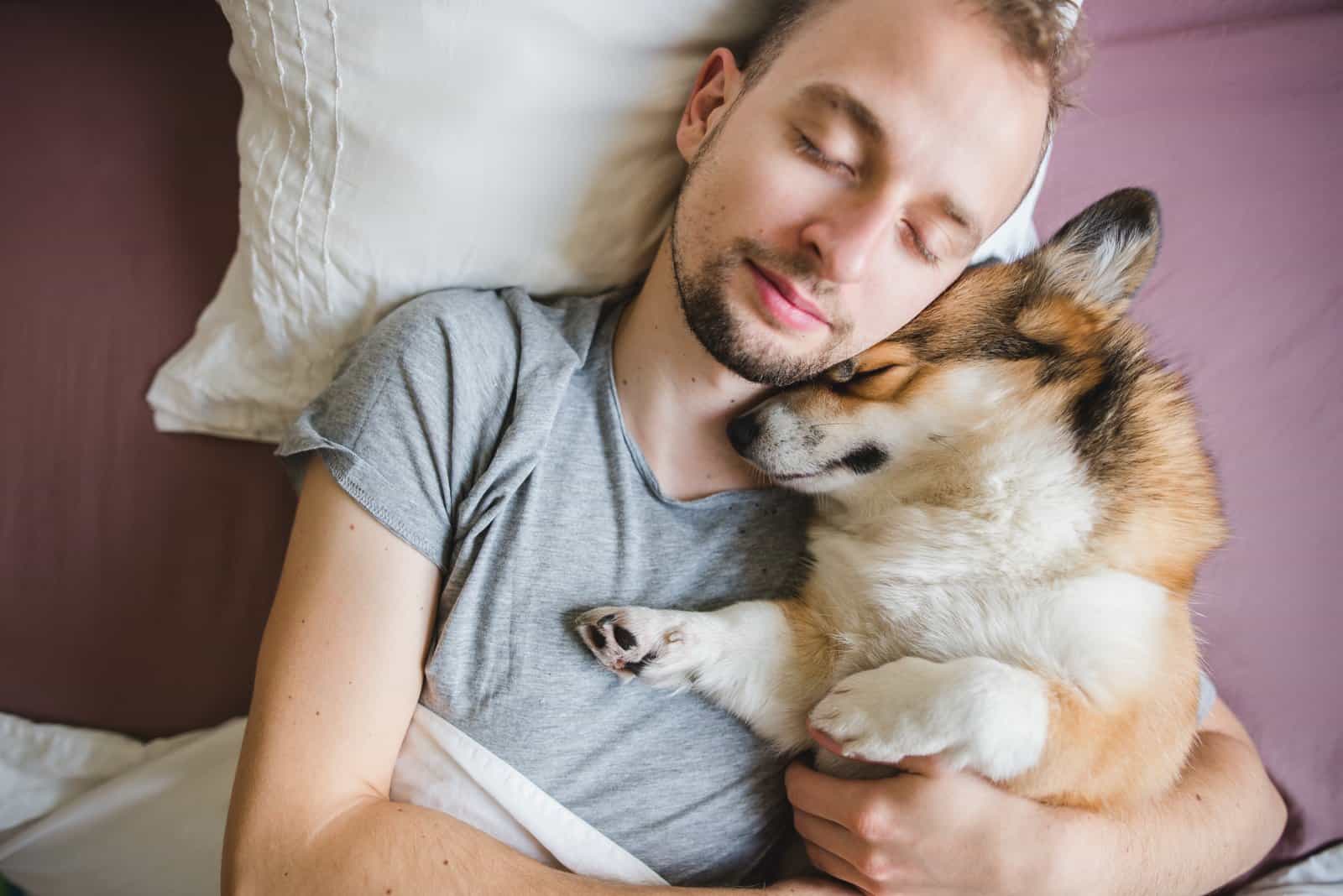 Perro y dueño durmiendo en la cama