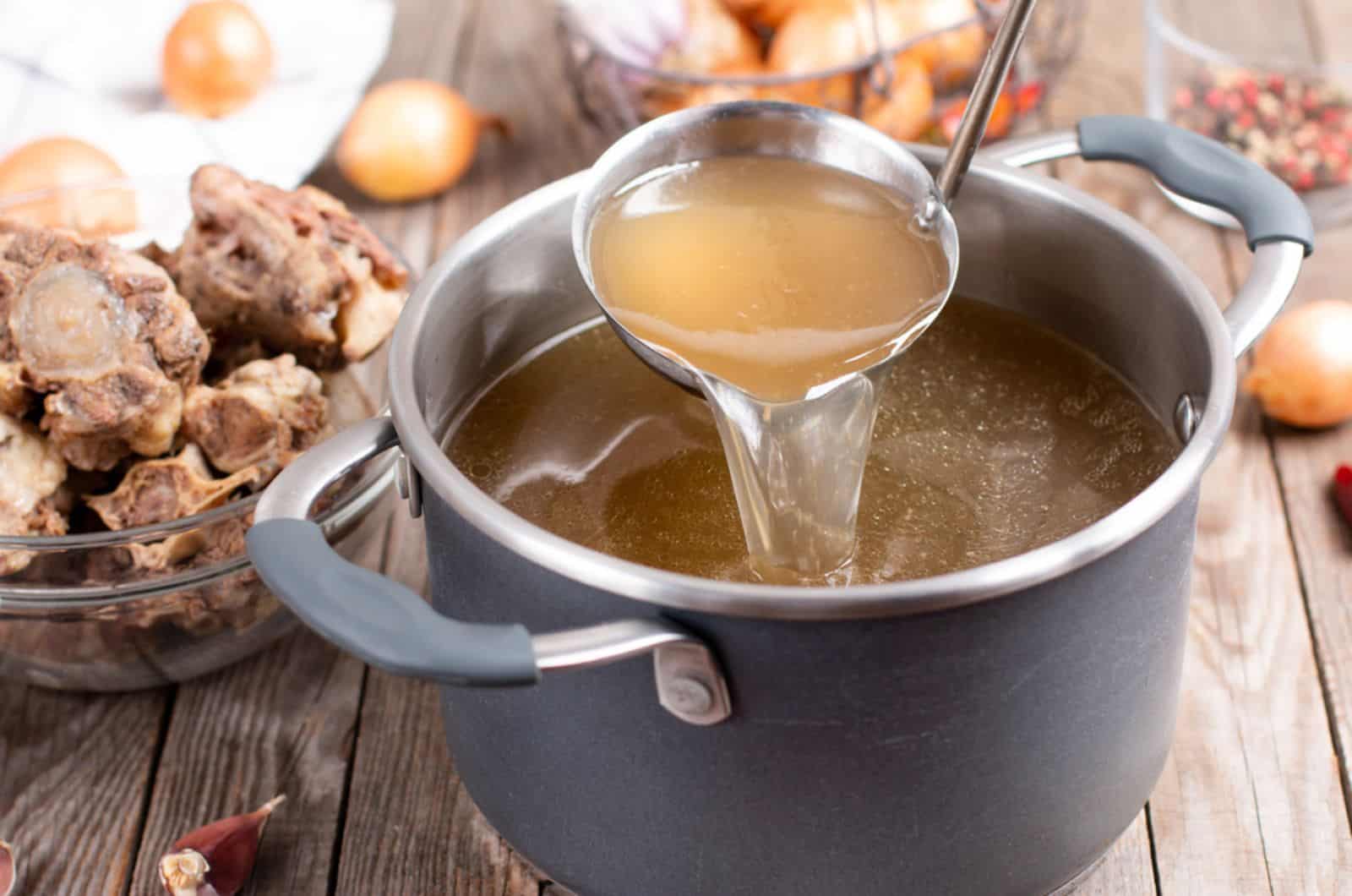 Olla con caldo con un cucharón en la mesa