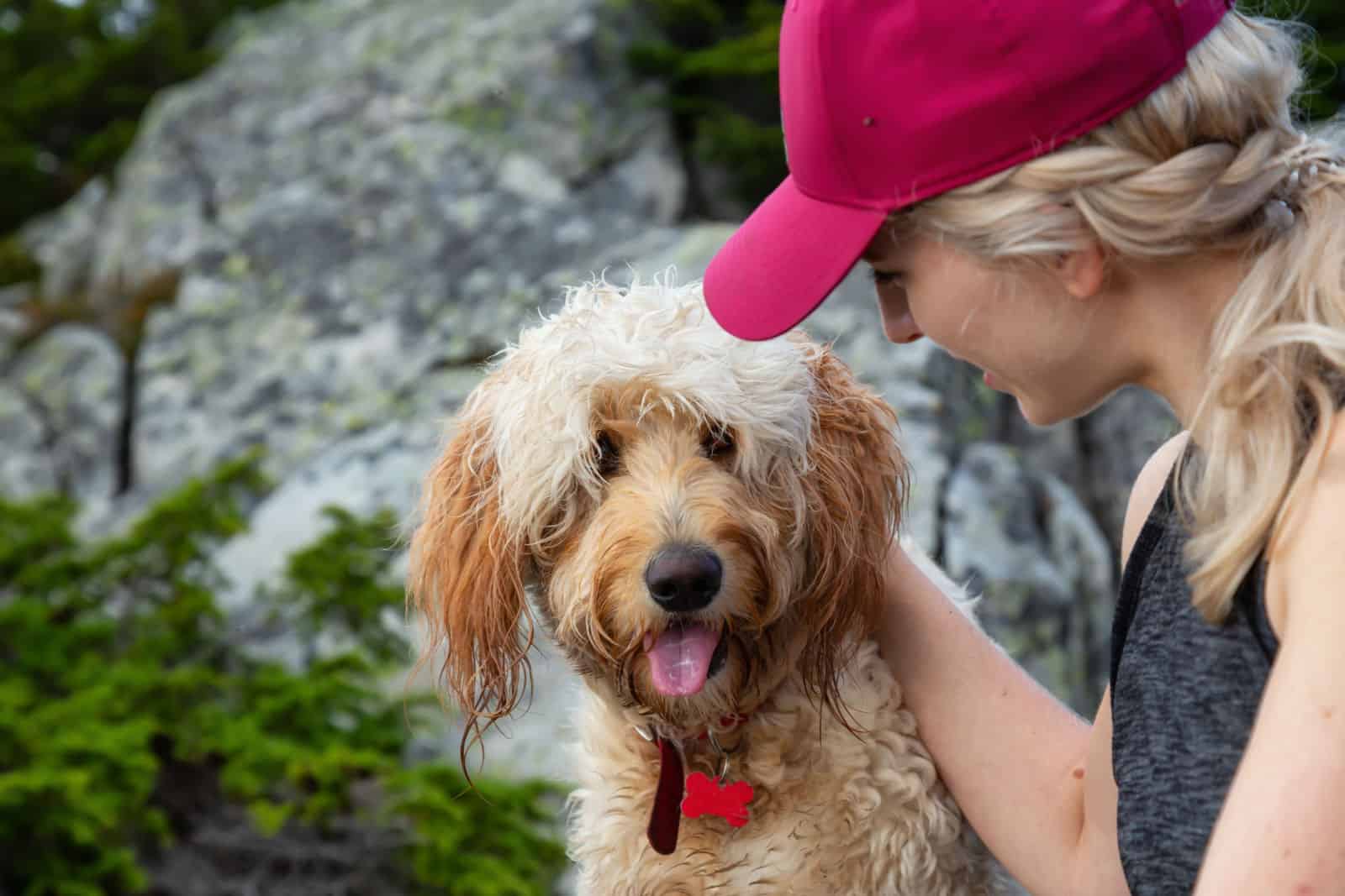 Mujer excursionista pasa tiempo con su perro en la naturaleza.
