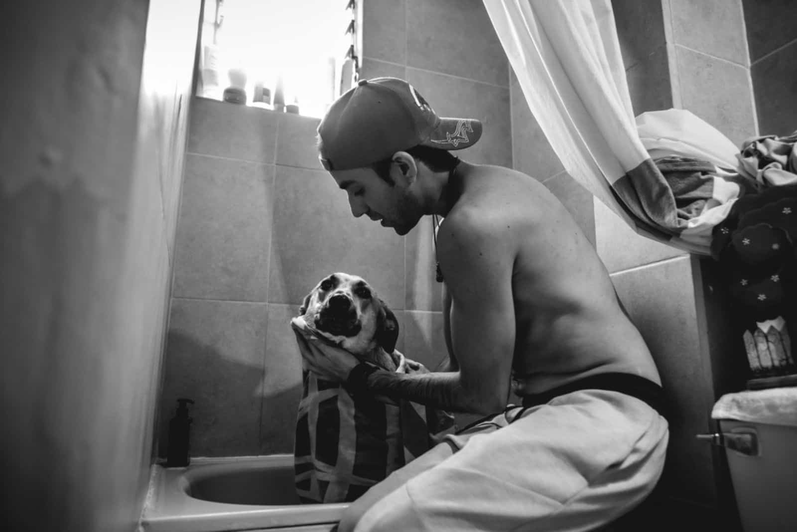 un hombre con un pastor alemán en el baño