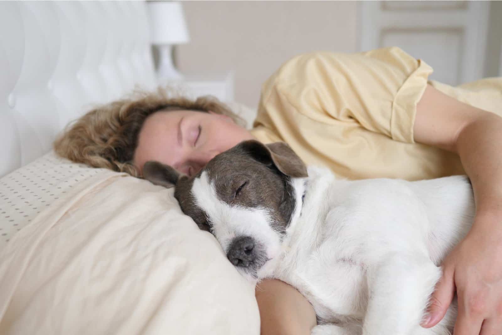perro y mujer durmiendo en la cama