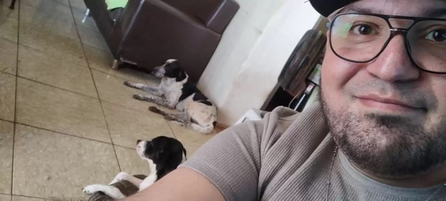 foto de un hombre con dos perros en el fondo