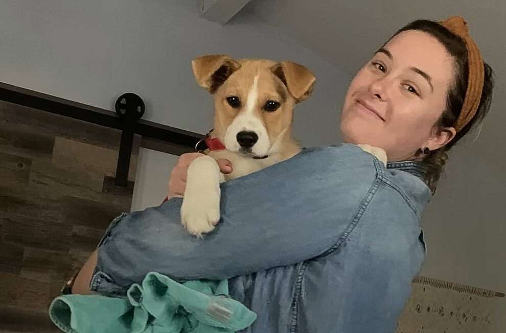 mujer sonriente con perro en brazos posando