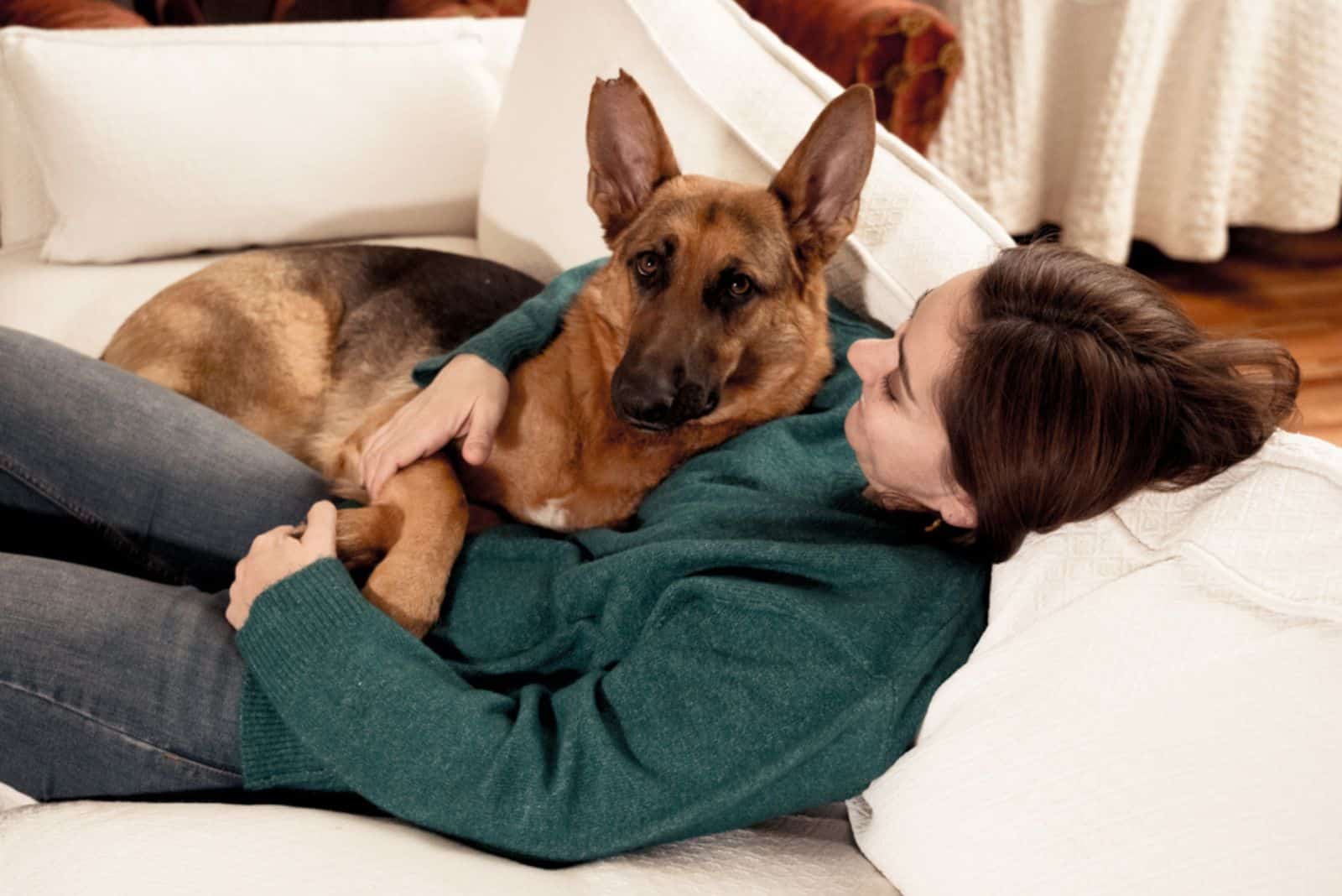 mujer abrazando a su perro pastor alemán