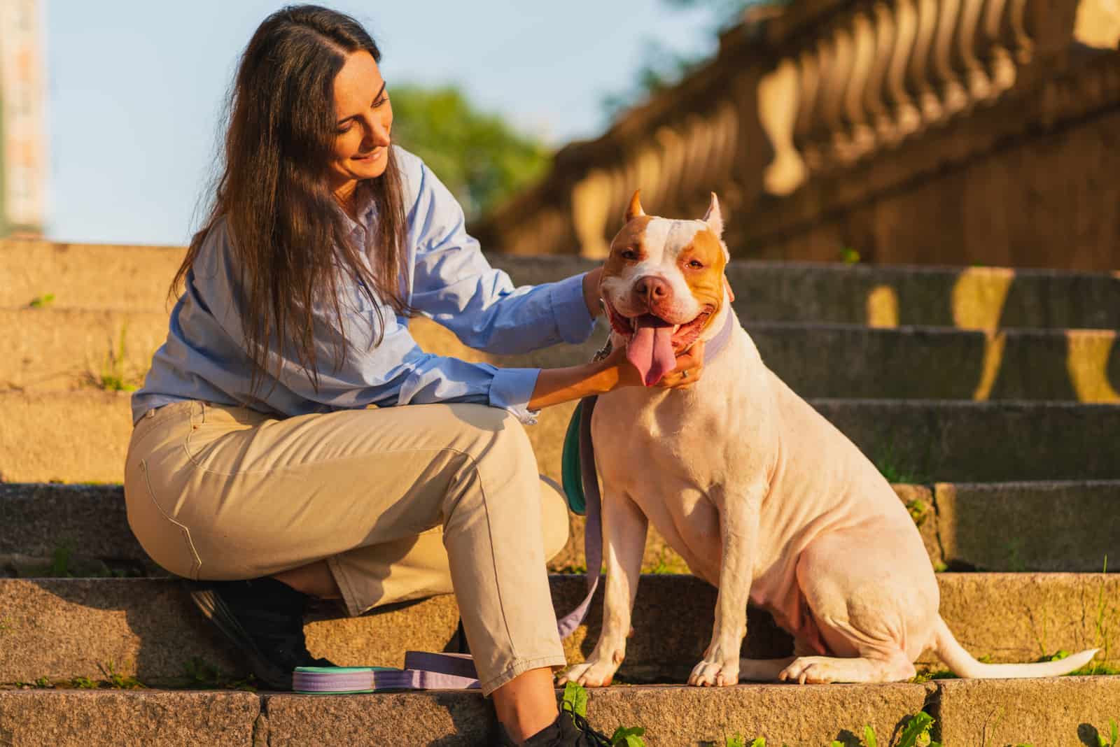 mujer posando con su pitbull terrier