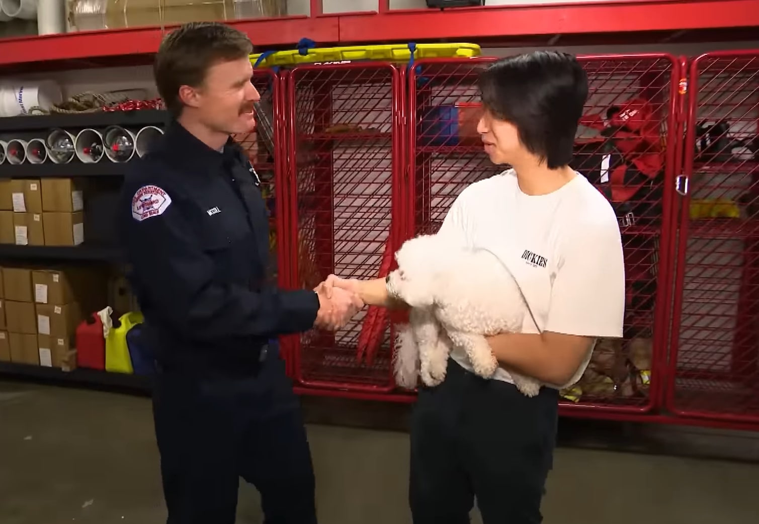 mujer estrechando la mano de un hombre mientras sostiene un perro