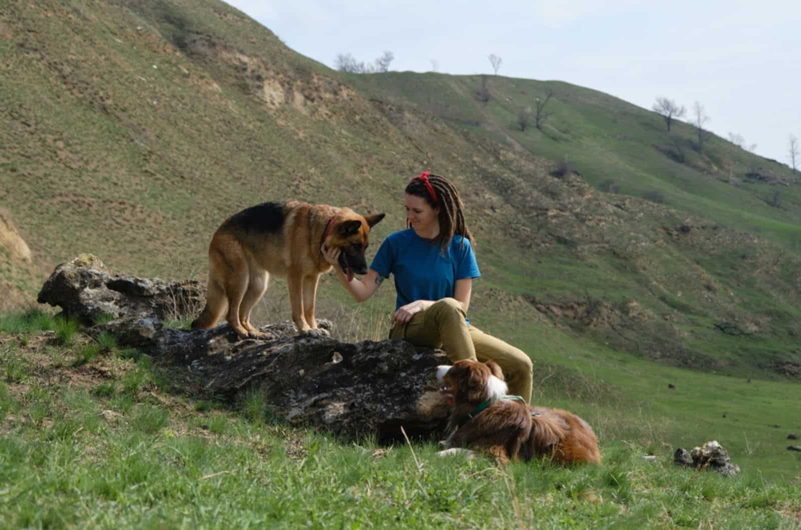 mujer acariciando a un perro pastor alemán en la naturaleza